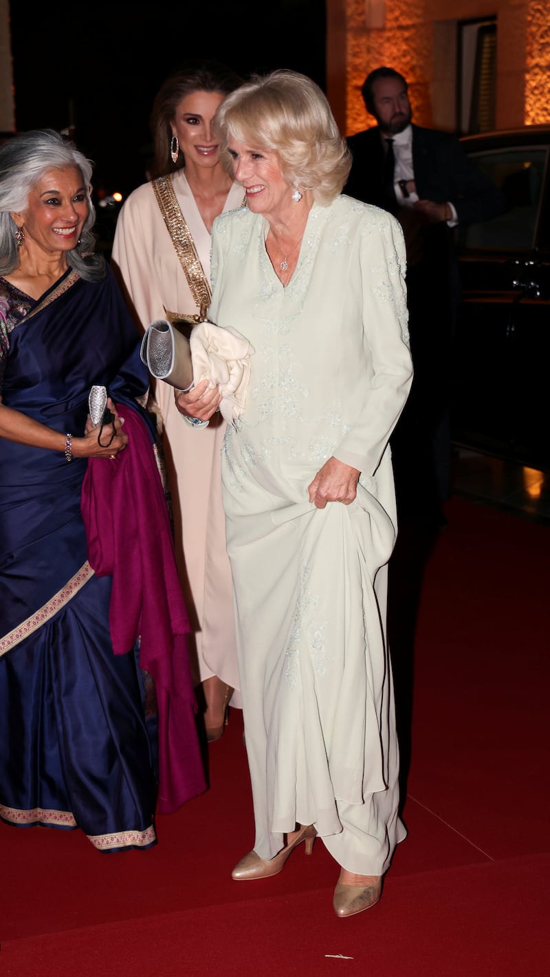 The queen consort, in a white Anna Valentine gown, attends a private dinner at the Al Husseiniya Palace in Amman on November 16, 2021. Reuters