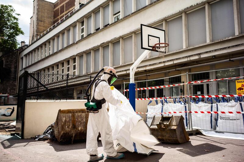 A worker holds a canvas bag as he takes part in a clean-up operation at Saint Benoit school near Notre-Dame cathedral in Paris during a decontamination operation over lead poisoning fears. AFP