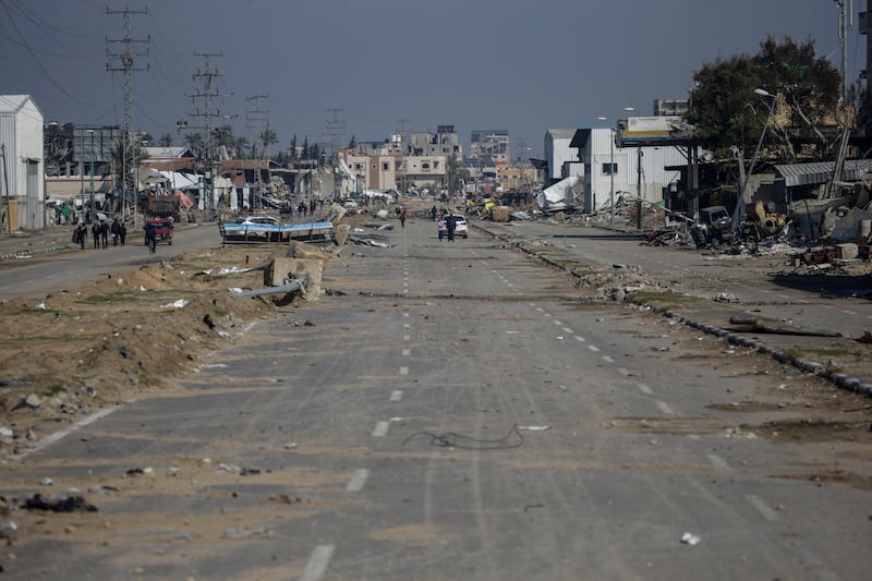 Palestinians move along Salah Al Din road after an Israeli air strike on Al Maghazi refugee camp. EPA