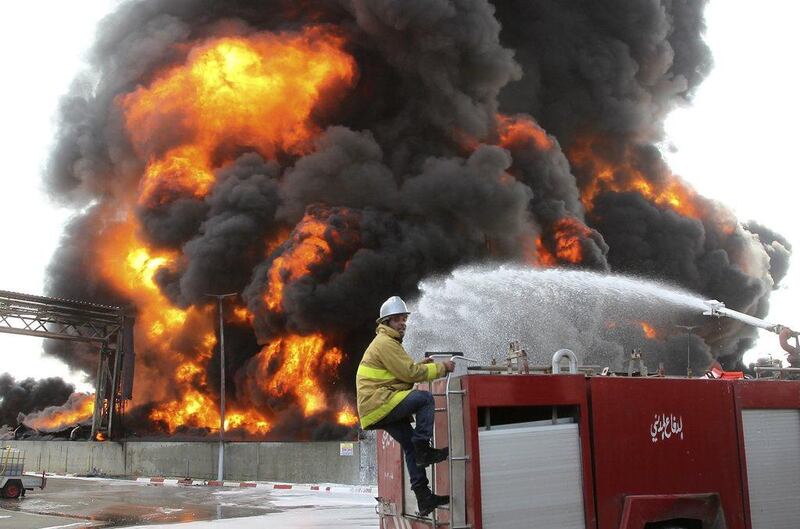 A Palestinian firefighter works during efforts to extinguish a fire at Gaza's main power plant, which witnesses said was hit in Israeli shelling, in the central Gaza Strip July 29, 2014. Israel's military pounded targets in the Gaza Strip on Tuesday after Prime Minister Benjamin Netanyahu said his country should prepare for a long conflict in the Palestinian enclave, squashing any hopes of a swift end to 22 days of fighting. Witnesses said the fuel storage at Gaza's main power plant was struck, sending thick black plumes of smoke up into the air and leaving Gaza City and many other areas in the battered enclave without electricity. Israel launched its offensive on July 8 saying it wanted to halt rocket attacks by Hamas and its allies. REUTERS/Ahmed Zakot (GAZA - Tags: POLITICS CIVIL UNREST)