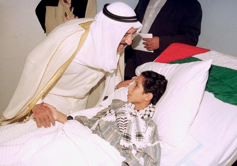 Kuwait Acting Prime Minister and Foreign Minister Sheikh Sabah al-Ahmad al-Sabah kisses a Palestinian boy, injured in clashes with Israeli forces, at a hospital 24 October 2000. Sheikh Sabah visited five Palestinians who arrived in Kuwait for medical care the previous day. (Photo by YASSER AL-ZAYYAT / AFP)