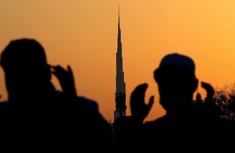 Against a backdrop of the world's tallest building, Burj Khalifa, in Dubai, men wearing masks to curb the spread of coronavirus outbreak perform an Eid Al Fitr prayer to mark the end of Ramadan in the UAE. AP Photo