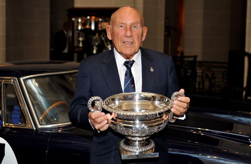 Stirling Moss holds the British GP winners trophy which he won in 1955 as he stands in front of the Ferrari 250 GT SWB, which he raced to victory in the Goodwood Tourist Trophy in 1961. PA