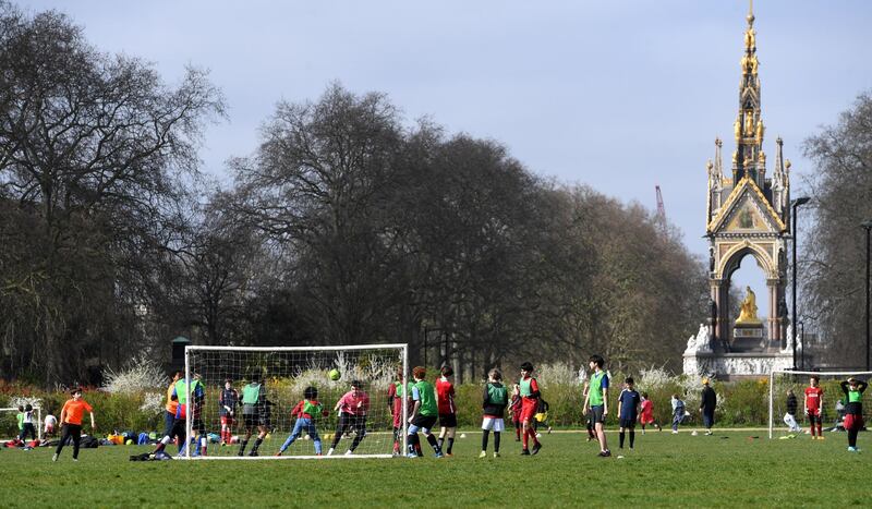 People play football in Hyde Park in London. EPA