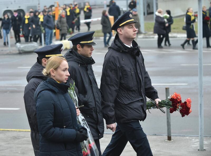 Pilots and crew members attend a tribute ceremony of the 11 Ukrainians who died in a plane mistakenly shot down by Iran during a spike in tensions with Washington, which arrived in Boryapil airport, outside Kiev, on January 19, 2020. - Ukarine's President, Prime Minister and other officials attend the solemn ceremony at Kiev's Boryspil airport to see caskets with the remains of the downed plane's nine Ukrainian flight crew and two passengers being removed from the aircraft. (Photo by Sergei SUPINSKY / AFP)