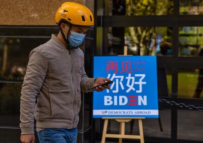 epa08797604 A delivery man passes by a board inviting people to a watch party for the US election results hosted by Democrats Abroad in a restaurant in Shanghai, China, 04 November 2020. Republican candidate and incumbent Donald J. Trump and Democratic Party candidate Joe Biden are jostling for Electoral College votes need to secure the presidency. To win a candidate needs to acquire 270 Electoral College votes.  EPA/ALEX PLAVEVSKI