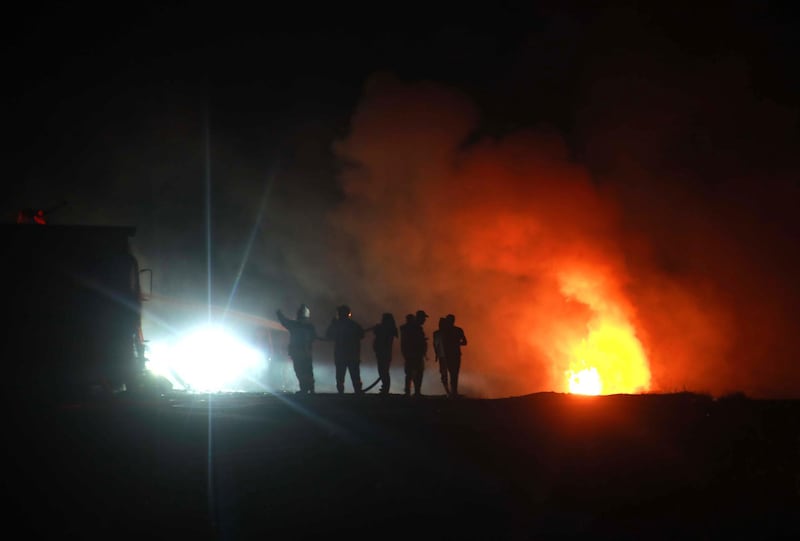 Syrians gather at the still flaming spot where Abu Hassan al-Muhajir, the Islamic State group's spokesman was reportedly killed in a raid in the northern Syrian village of Ayn al Bayda near Jarablus on October 27, 2019.  The right-hand of Baghdadi and the spokesman for IS, was targeted in a coordinated operation between the Syrian Democratic Forces (SDF) intelligence and the US army, SDF chief Mazloum Abdi said on Twitter.  / AFP / Aaref WATAD
