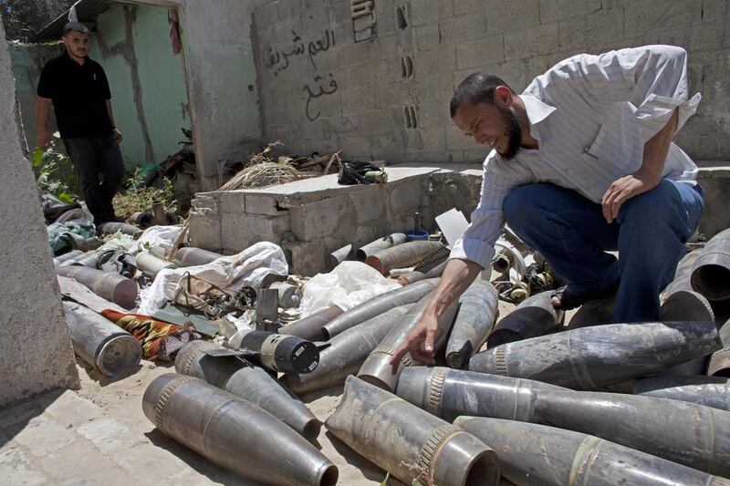Hazem Abu Murad, head of field operations in Gaza’s police bomb squad, examines a collection of unexploded Israeli munitions at a police station in Nuseirat in central Gaza on August 7, 2014. Heidi Levine for The National