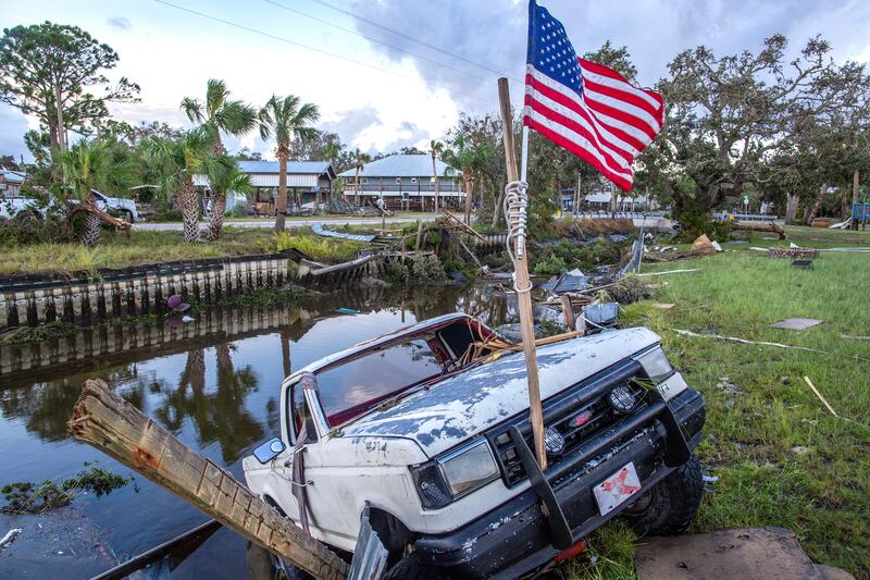 A car hangs on the ledge of a channel full of debris after Hurricane Idalia made landfall in Florida. EPA