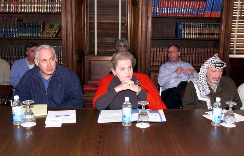 US Secretary of State Madeleine Albright (C) sits next to at Israeli Prime Minister Benjamin Netanyahu (L) and Palestinian leader Yasser Arafat (R) during a working meeting in the Houghton House at the Wye River Plantation Conference Center in Maryland 16 October.  The Houghton House is the home to the Palestinian delegation during the second day of a five-day secluded retreat that hopes to pave the wave to a peace settlement. AFP PHOTO (Photo by HO / WHITE HOUSE / AFP)