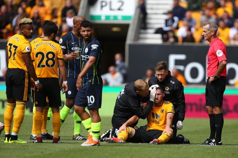 Wolverhampton Wanderers' Irish defender Matt Doherty, centre, receives treatment on the pitch. AFPs. /