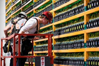 Two construction workers at the bitcoin mining company Bifarms in Saint Hyacinthe, Quebec. Bitcoin investors are coming around to regulatory oversight. AFP