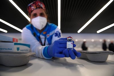 A health worker holds a bottle of the AstraZeneca vaccine against Covid-19 during a mass vaccination campaign by SUMMA 112 (Medical Emergency Services of Madrid) at the Wanda Metropolitan stadium in Madrid on February 25, 2021. So far, some 1.2 million people have been vaccinated in Spain since the start of the immunisation campaign which began just after Christmas with care home residents first in line along with their carers.  / AFP / PIERRE-PHILIPPE MARCOU
