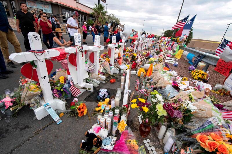 People leave flowers at a makeshift memorial for shooting victims at the Cielo Vista Mall Walmart, in El Paso, Texas, on August 6, 2019. The August 3 shooting left 22 people dead. US President Donald Trump will visit the Texan border city August 7, and will also travel to Dayton, Ohio where a second mass shooting early August 4 left another nine dead. 
 / AFP / Mark RALSTON
