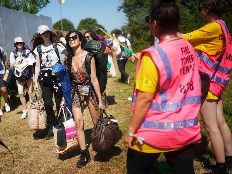 A festivalgoer is sprayed with water by a steward to cool them down on the first day of the festival. Reuters