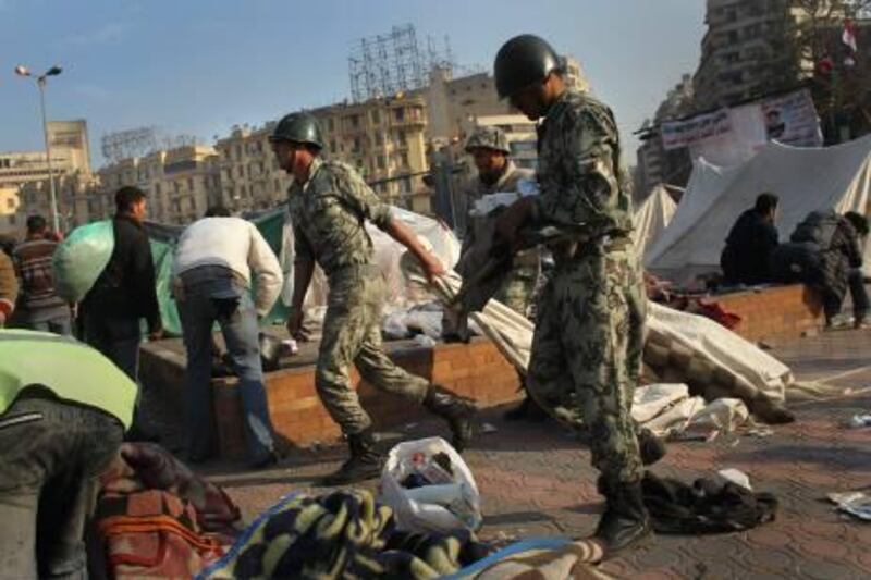 CAIRO, EGYPT - FEBRUARY 13:  Egyptian soldiers haul away makeshift tents after the army ordered the protesters' encampments closed in Tahrir Square on February 13, 2011 in Cairo, Egypt. Two days after the resignation of Hosni Mubarak, the Egyptian army is asserting its control.  (Photo by John Moore/Getty Images) *** Local Caption ***  GYI0063444503.jpg