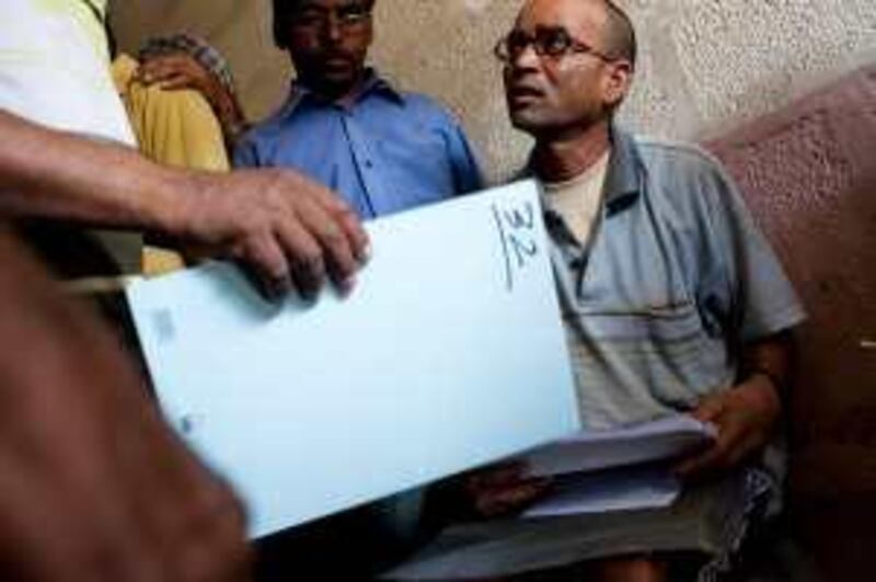 03/09/2009 - Abu Dhabi, UAE - Phool Chand, right, of India, shows discrepancies in his paperwork that are resulting in him receiving less money than he should after the employer abandoned him at a labour camp in Musaffah.   (Andrew Henderson / The National) *** Local Caption ***  090915_Laborers_093.jpg