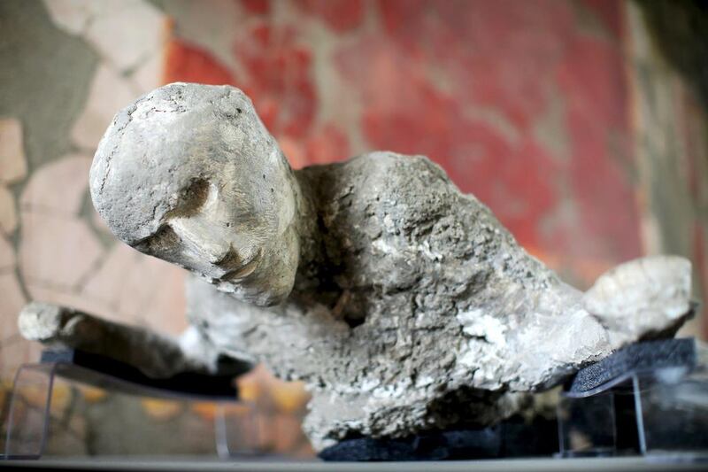The plaster cast of a Pompeii victim lies in a frescoed room.   Alessandro Bianchi / Reuters