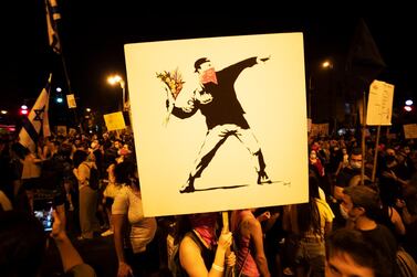Banksy is unperturbed by his work the 'Flower Thrower' being used as an emblem of protest; he is less keen on it being moentised by corporations. EPA