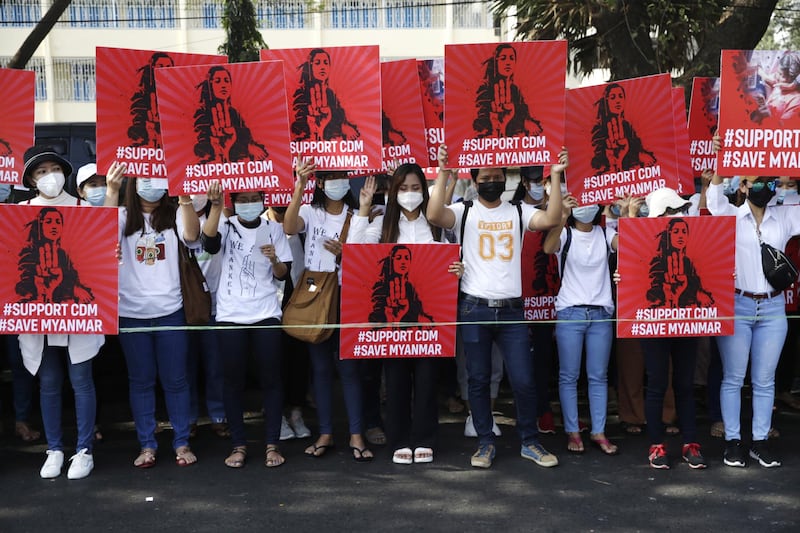 Demonstrators hold up placards supporting the CDM in Yangon, Myanmar. EPA