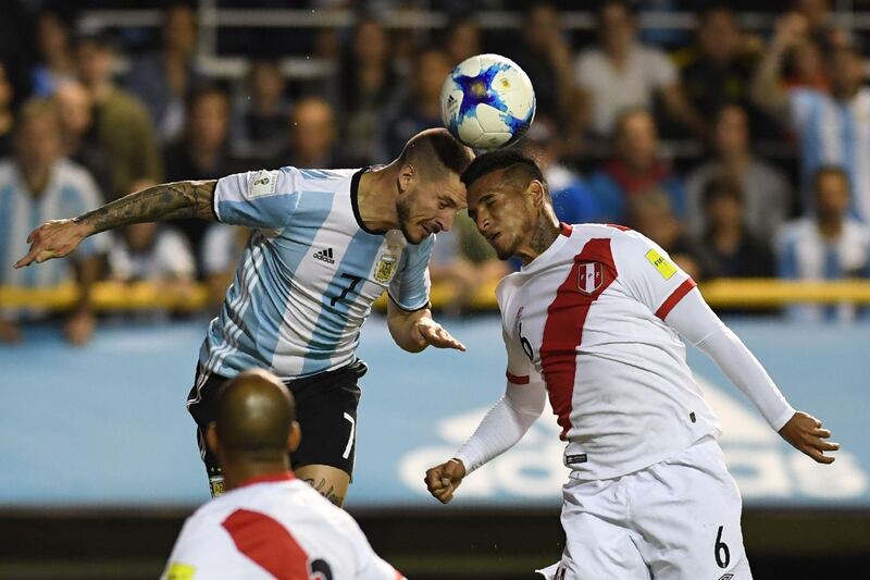 Argentina's Dario Benedetto and Peru's Miguel Trauco (R) vie for the ball during their 2018 World Cup football qualifier match in Buenos Aires on October 5, 2017. / AFP PHOTO / EITAN ABRAMOVICH