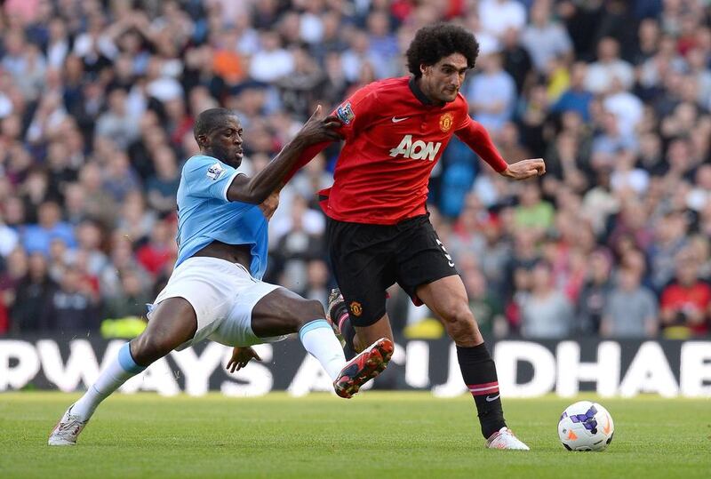 Manchester United midfielder Marouane Fellaini, right, is tackled by Manchester City's Yaya Toure. Andrew Yates / AFP