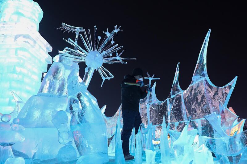 A Chinese worker makes an ice sculpture during the Harbin Ice and snow world in Harbin, Heilongjiang Province, China. Getty Images
