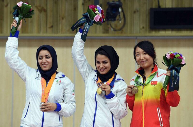 Najmah Khedmat, centre, of Iran, poses with her gold medal after the women's 10-metre air rifle individual final on Sunday at the Asian Games. To her left, Iran's Narjes Emamgholinejad and to her right, China's Binbin Zhand. Prakash Singh / AFP