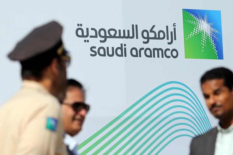 FILE PHOTO: The logo of Aramco is seen as security personnel stand before the start of a press conference by Aramco at the Plaza Conference Center in Dhahran, Saudi Arabia November 3, 2019. REUTERS/Hamad I Mohammed/File Photo