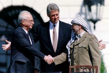 Yasser Arafat, right, shakes hands with Yitzhak Rabin in Bill Clinton's presence after signing their peace accord in Washington. Reuters