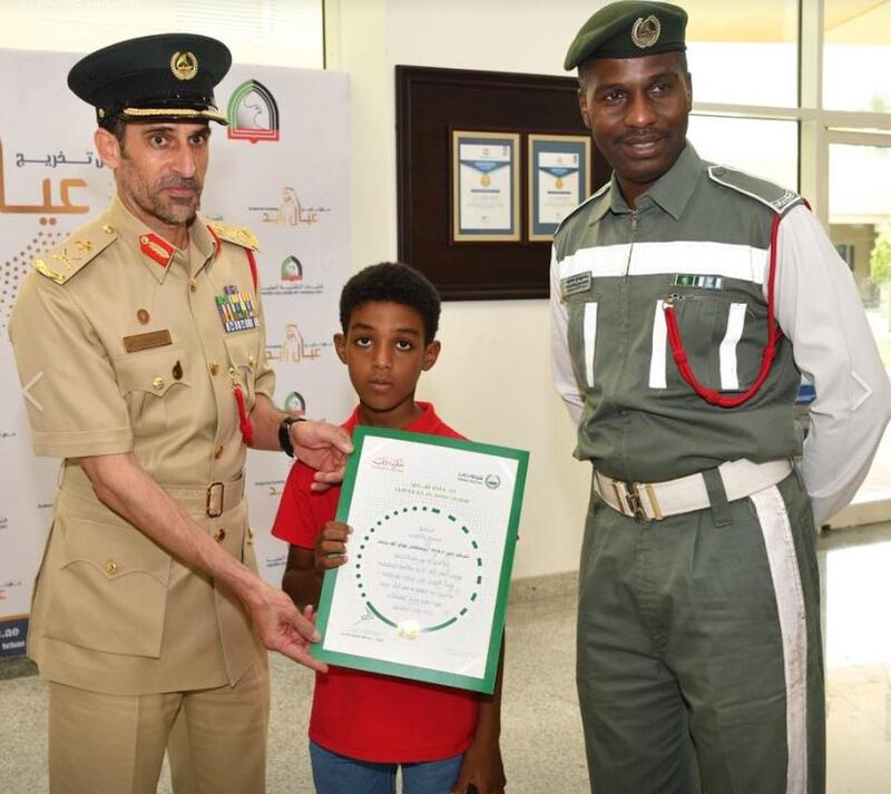 Mustafa Awad Yehia, right, with his young son, centre, was promoted following the incident. Dubai Police