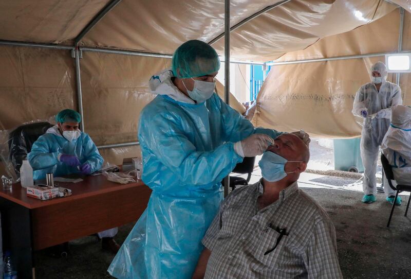 Doctors affiliated with the Palestinian Health Ministry perform checks and collect samples in a mobile tent in the West Bank city of Hebron.  AFP