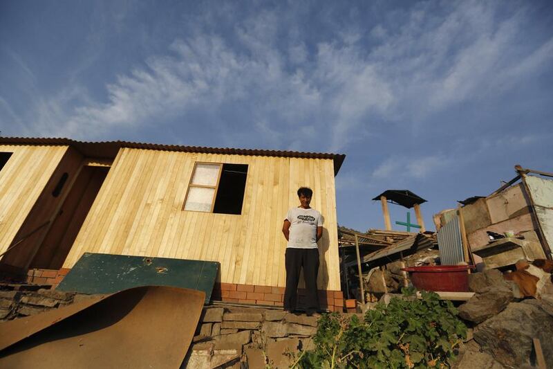 Roberto Taboada at his new house (left), next to the old one (right), in Gosen City. Taboada has lived for years in Gosen but recently saved enough from working odd jobs as a handyman to build a solid home. Mariana Bazo / Reuters