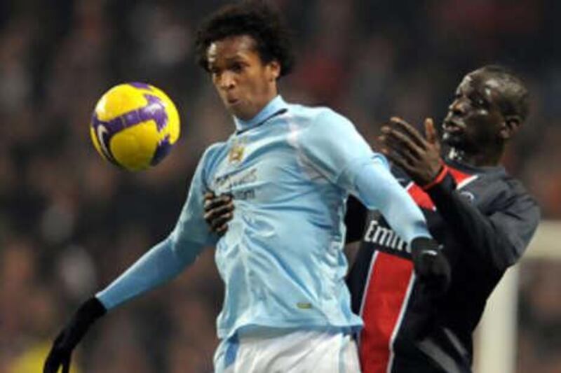 Manchester City's Brazilian striker Jo, left, shields the ball from PSG's Mamadou Sakho.