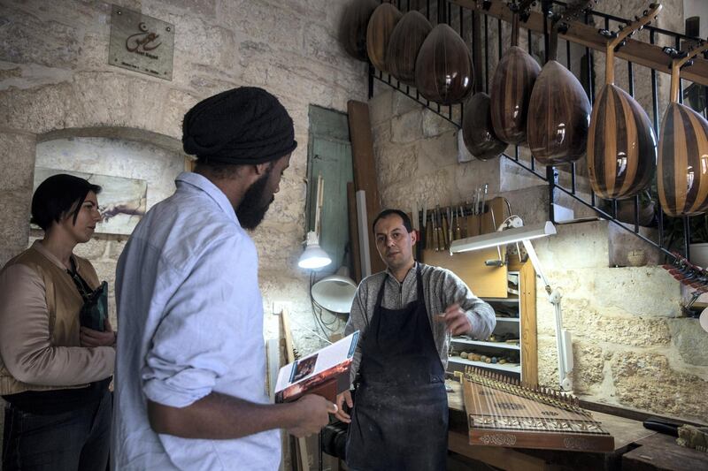 String instrument maker Aref Sayed speaks to a group on a the artist tour as he speaks about the instruments he makes and repairs.
Sayed is the only maker in Palestine of the qanun, an instrument that plays a role similar to the bass in western music. One of only three oud makers in the West Bank, Sayed has customers from the West Bank, the Galilee region of northern Israel, the US, Canada, Germany and the UK. Sometimes instruments for him to repair arrive from Syria and Egypt.(Photo by Heidi Levine for The National).