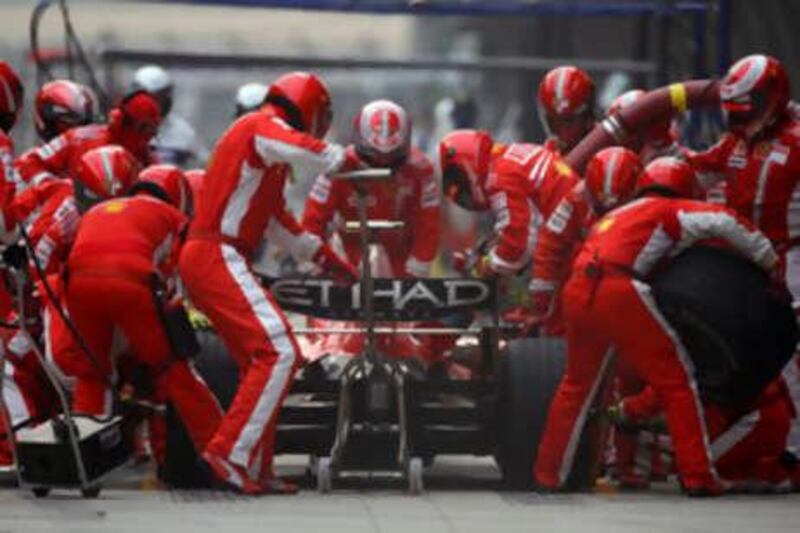 The Ferrari mechanics get to work on a pit-stop for their Brazilian driver Felipe Maasa.