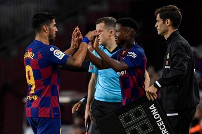 Barcelona's Uruguayan forward Luis Suarez (L) is substituted off for Barcelona´s Guinea-Bissau forward Ansu Fati during the Spanish league football match between FC Barcelona and Villarreal CF at the Camp Nou stadium in Barcelona, on September 24, 2019. / AFP / LLUIS GENE
