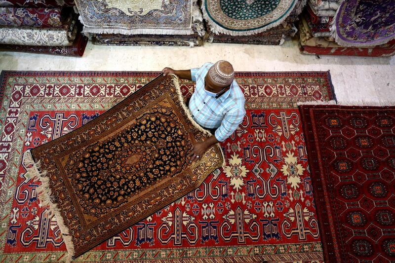 A vendor arranges carpets in his shop at Central Souq in Sharjah. Getty Images