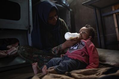 A woman feeds an infant inside a truck where they are living in the Rafah camp near the Egyptian border in southern Gaza. EPA