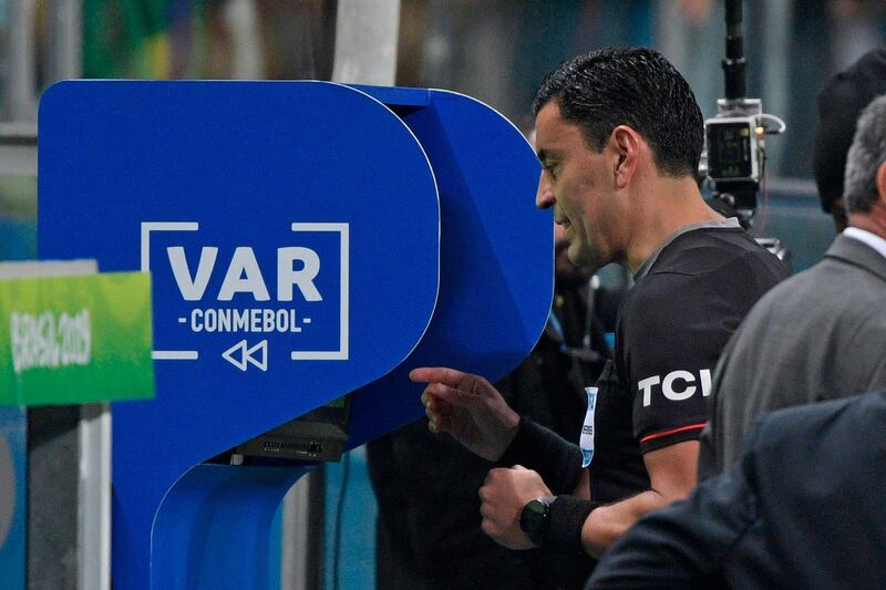 Referee Tobar checks the VAR before showing the red card to Paraguay's Balbuena. AFP