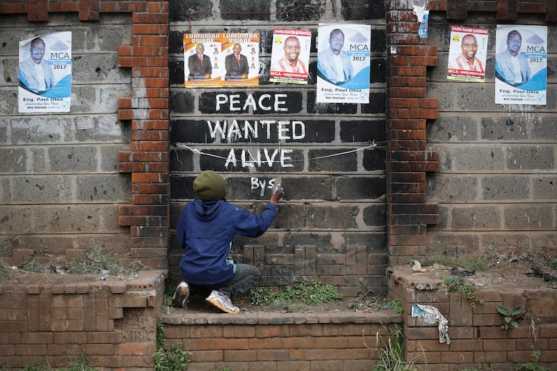 Street artist Solomon Muyundo, also known as Solo7, paints a message of peace on the wall in Kibera slum, one of the opposition leader Raila Odinga's strongholds in the capital Nairobi. DAI KUROKAWA / EPA
