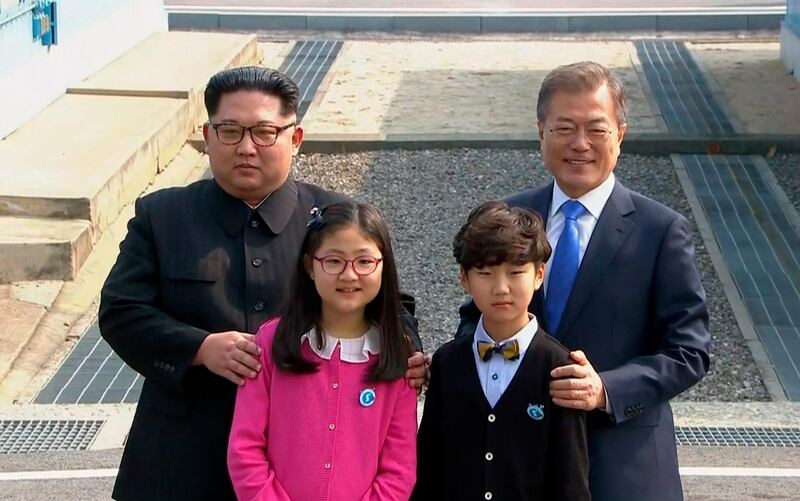 The leaders pose with children from the only school in demilitarized zone. Korea Broadcasting System via AP