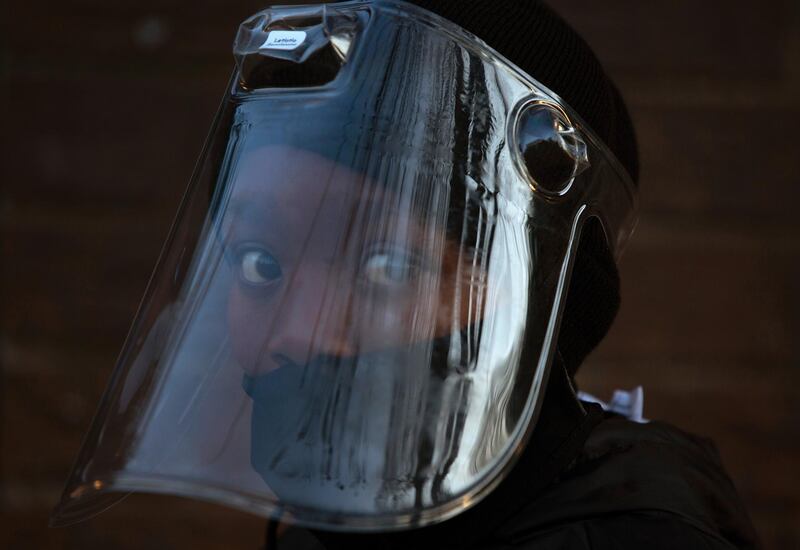 A student, wearing a face mask and shield, returns to the Melpark Primary School in Johannesburg. AP Photo