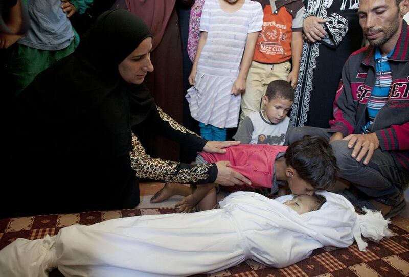 Relatives gather around the tiny body of Jud during her funeral in Gaza City on June 25, 2014. The attack also injured her sister and cousin. Heidi Levine  for The National 