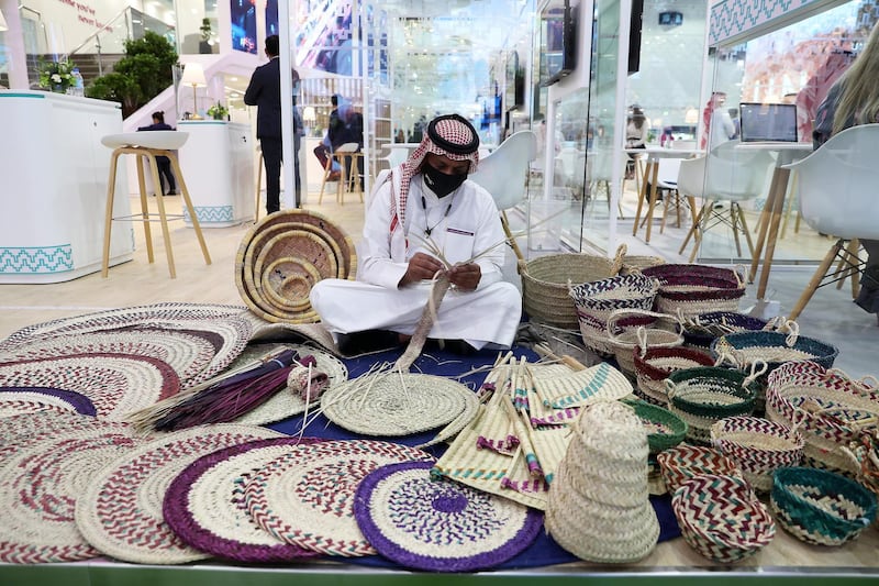 Artist making items from palm leaves at the Saudi Arabia stand during the Arabian Travel Market held at Dubai World Trade Centre in Dubai on May 16,2021. Pawan Singh / The National. Story by Deena