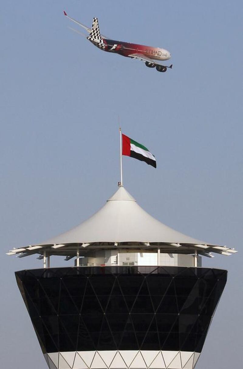 An Etihad Airways Airbus A340 flies over the control tower at Yas Marina Circuit, in Abu Dhabi. Ali Haider / EPA