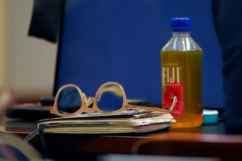 Depp’s glasses, beverage and sketchbook in the courtroom. AFP