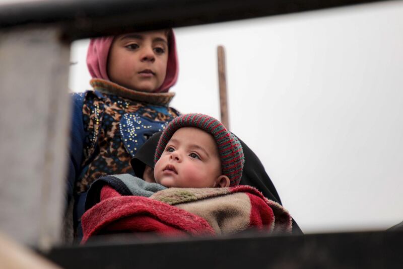 A child holds a baby atop a truck as a convoy of Syrians fleeing towns and villages in the countryside of the northern province of Aleppo passes through the town of Ghazaouia toward safer areas to seek refuge from reported bombing by pro-regime forces.  AFP