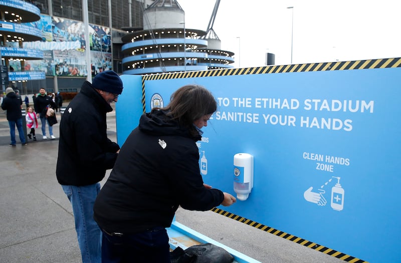 Fans outside the Etihad Stadium in Manchester sanitise their hands before attending a match. Reuters