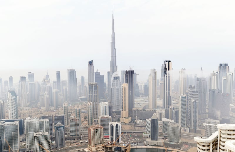 Buildings in Downtown Dubai loom from the gloom amid stormy skies and rain. Chris Whiteoak / The National